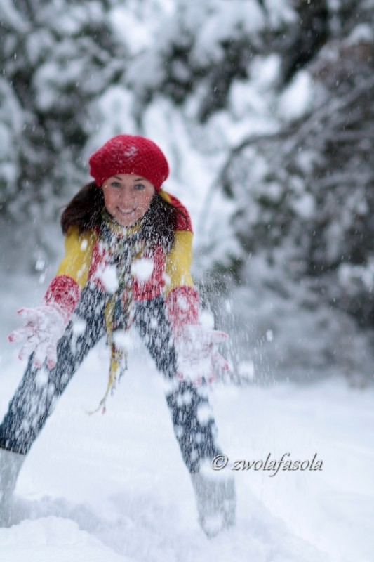 woman playing on the snow in the red cap and gloves_533x800